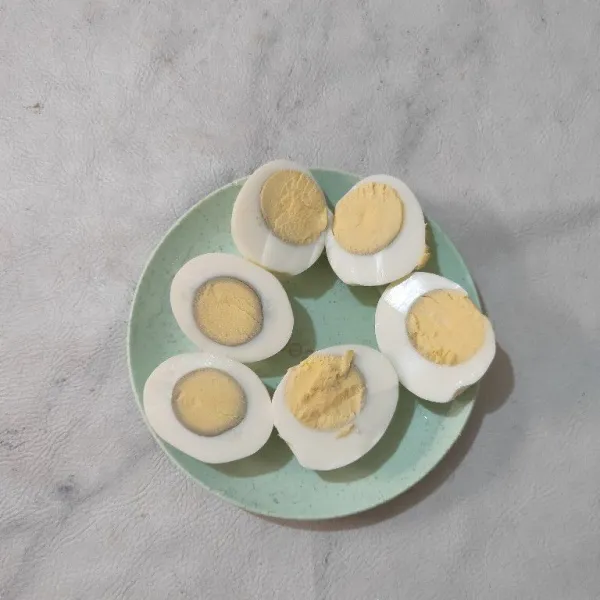 Belah telur menjadi dua bagian. Sisihkan.