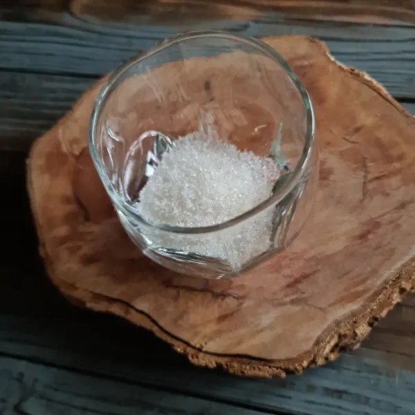 Masukkan gula pasir ke dalam gelas.