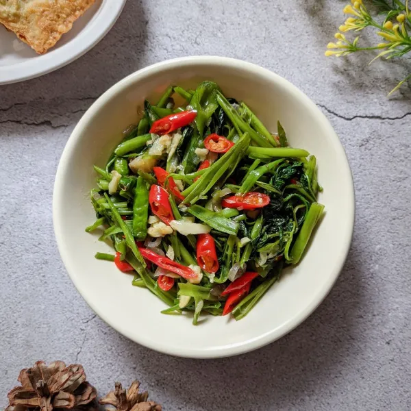 Pindahkan tumisan kangkung ke wadah saji.