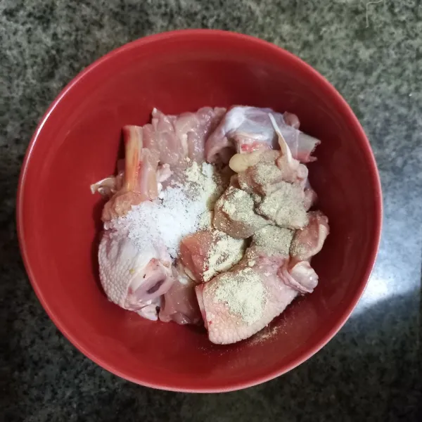 Lumuri potongan paha ayam dengan bumbu marinasi.