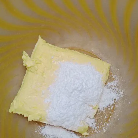 Campurkan butter margarin dan gula halus.