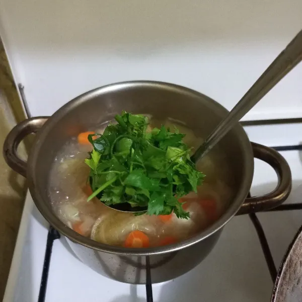 Tambahkan irisan daun bawang dan seledri, masak sebentar saja.