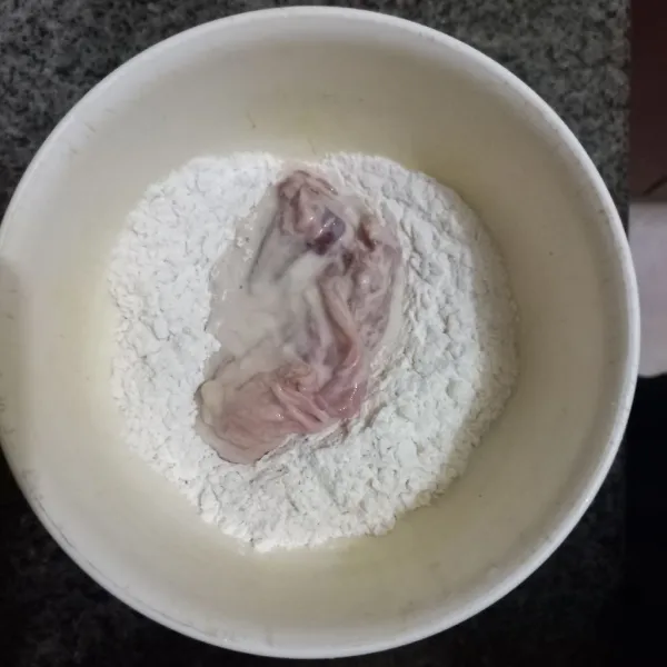 Celupkan potongan ayam pada adonan basah kemudian gulingkan pada tepung terigu, ulangi dan lakukan sekali lagi.