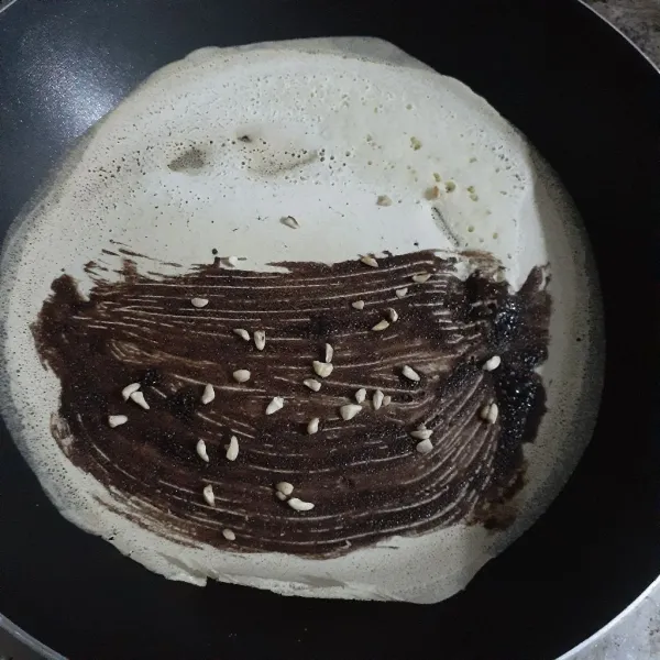 Alas pan anti lengket dengan loyang kue kering bekas atau apa saja yang bisa buat alas. Dialas biar crepes tidak cepat gosong dan panaskan pan anti lengket dengan api sedang cenderung kecil lalu tuang satu centong sayur kecil adonan crepes dan masak hingga adonan crepes kecoklatan. Jika suka boleh oleskan saus coklat dan taburi dengan cacahan kacang.