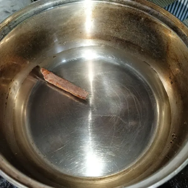 Rebus air dan kayu manis di panci.