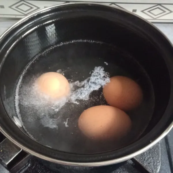 Didihkan air rebus telur selama 7 menit, angkat biarkan dingin lalu kupas kulitnya.