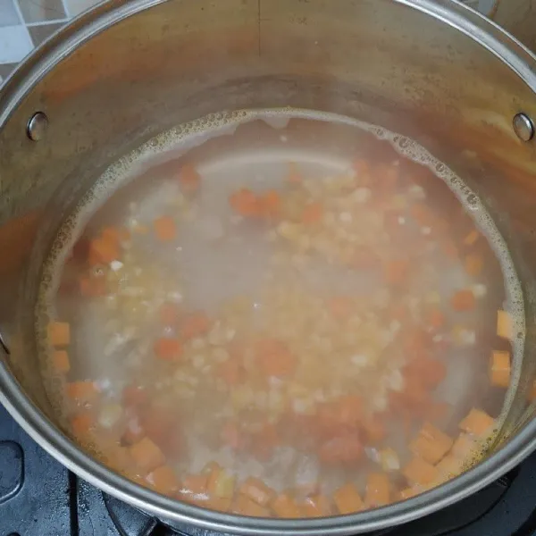 Didihkan air, masukkan wortel dan jagung terlebih dahulu.