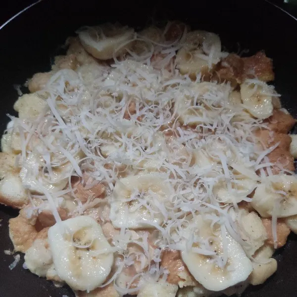 Beri toping pisang dan keju parut, tutup dan gunakan api kecil. Masak hingga matang.