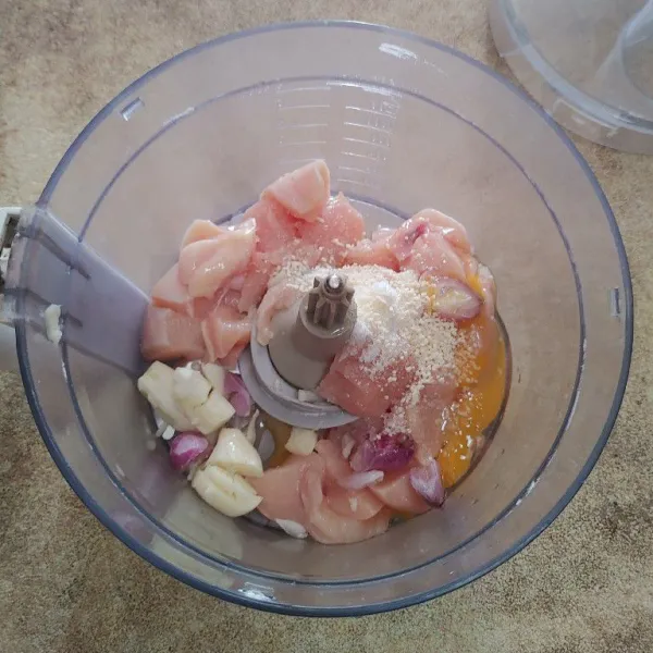 Masukan daging ayam kedalam food prosesor. Tambahkan bawang putih, bawang merah telur, garam dan kaldu jamur. Haluskan.