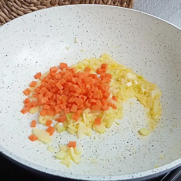 Lelehkan 1 sdm margarin kemudian tumis bawang bombai, bawang putih dan wortel. Tumis hingga wortel layu.