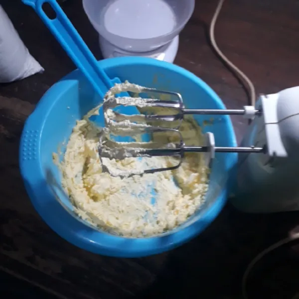 Mixer mentega dan gula halus dengan kecepatan tinggi selama 1 menit.