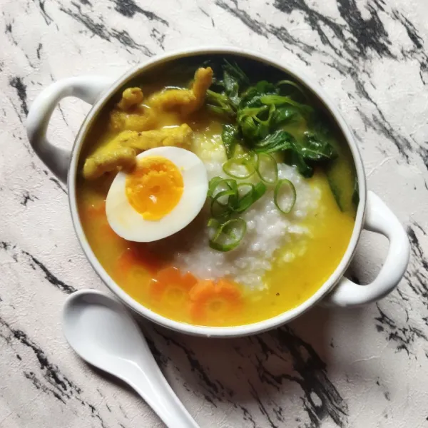 Penyajian: tata bubur dalam mangkuk, tata telur dan sayur rebus. Sajikan bubur hangat bersama kerupuk bawang dan sambal.