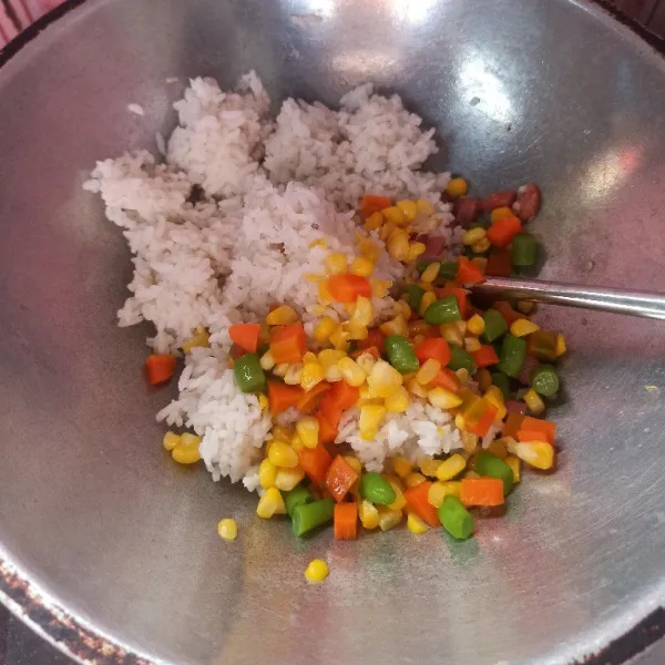 Selanjutnya masukkan nasi dan sayuran, aduk hingga tercampur rata.