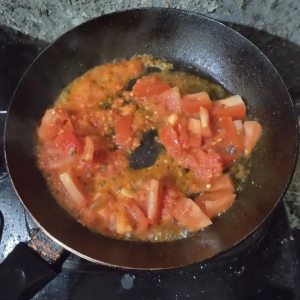 Tumis bumbu halus hingga harum, lalu tambahkan tomat. Tumis hingga layu.