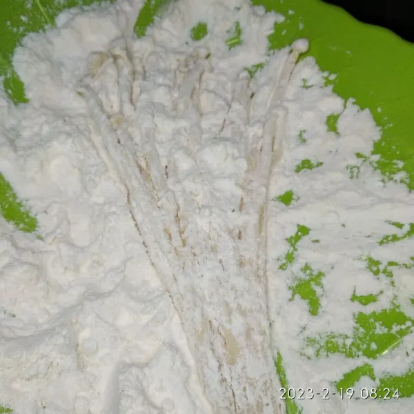 Kemudian pindahkan kedalan campuran tepung kering, gulingkan sampai semua terselimuti lalu kibaskan pelan sampai sisa tepung berjatuhan.