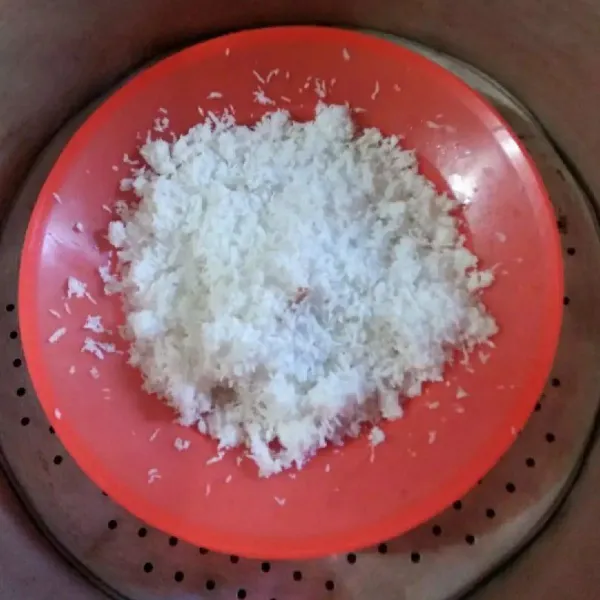 Siapkan kelapa parut dalam wadah lalu beri garam. Kemudian kukus selama kurang lebih 10 menit. Sisihkan jika sudah matang.