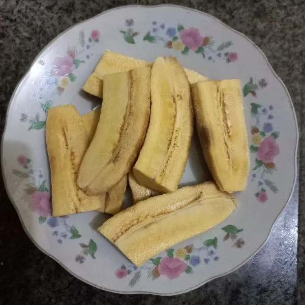 Kupas dan potong pisang menjadi 4 bagian.