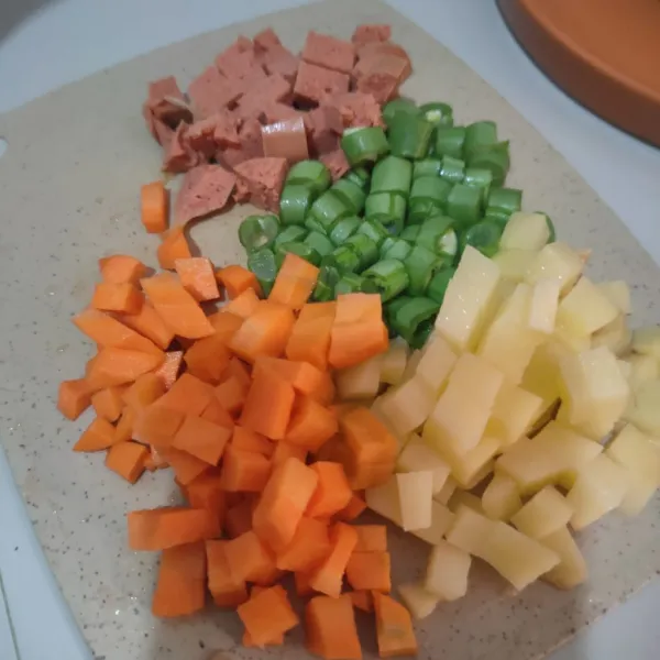 Potong dadu kecil sosis, wortel, kentang dan buncis.