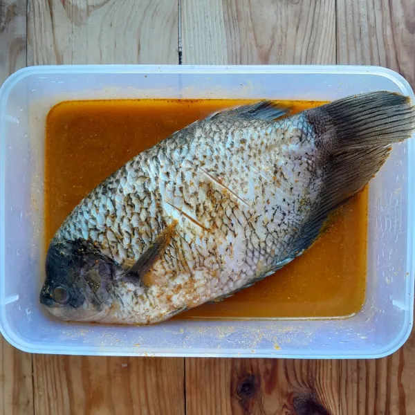 Larutkan 1 bungkus bumbu ikan goreng instan dengan 150 ml air, aduk rata. Masukkan ikan, aduk rata dan diamkan selama 15 menit.