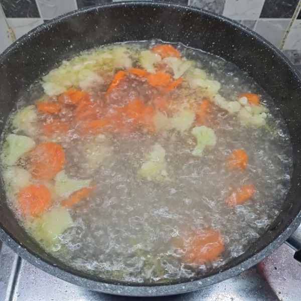 Tuang air, masak sampai mendidih. Masukkan wortel dan bunga kol, masak sampai ½ matang.