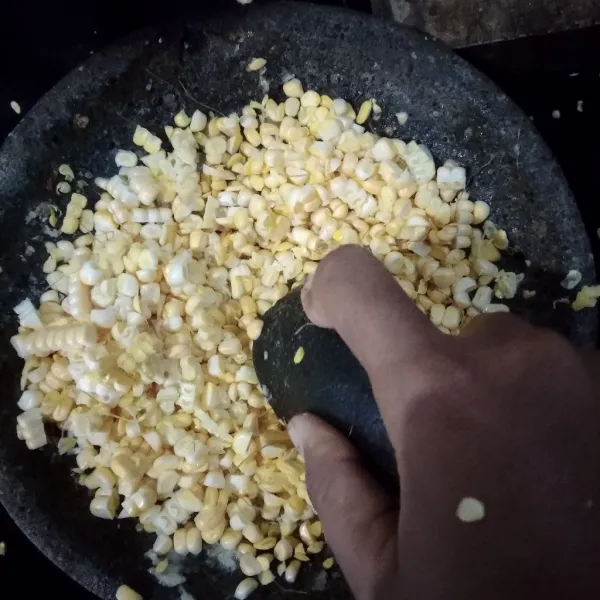 Sisir jagung di atas bumbu, kemudian tumbuk pelan jagung hingga cukup gepeng