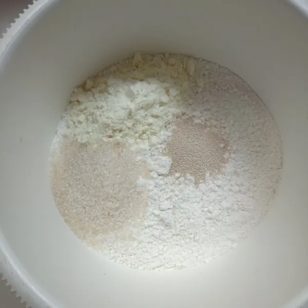 Dalam wadah masukkan tepung terigu, susu bubuk, gula dan garam, aduk rata.
