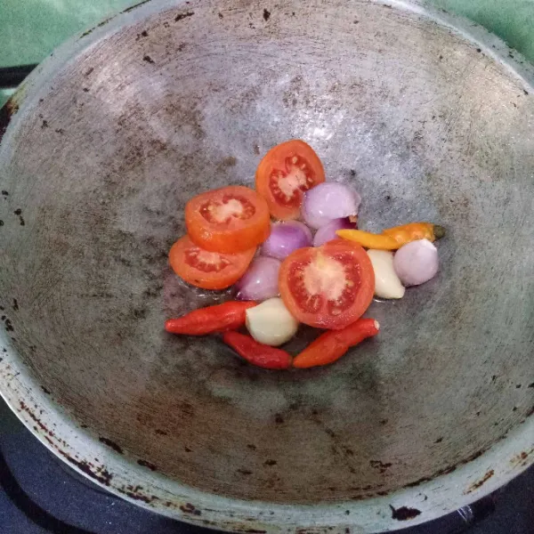 Goreng tomat merah, bawang merah, bawang putih dan cabai rawit.