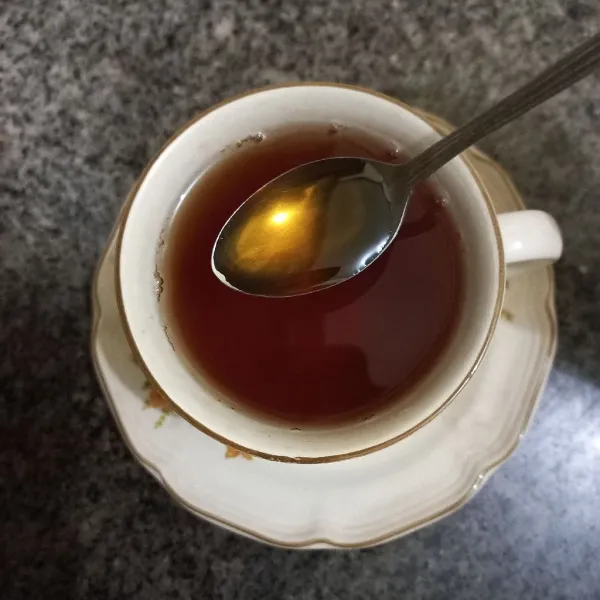 Tuang air teh panas pada gelas, beri madu secukupnya.