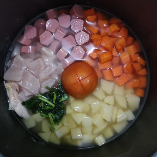 Masukkan ayam, wortel, kentang, sosis, daun seledri dan tomat lalu masak hingga matang.