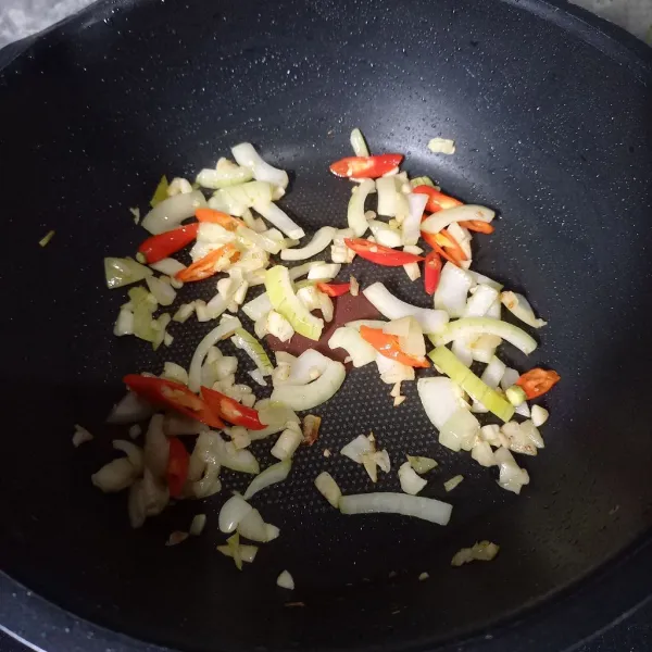 Tumis bawang bombay, bawang putih dan cabai merah sampai harum dan layu.