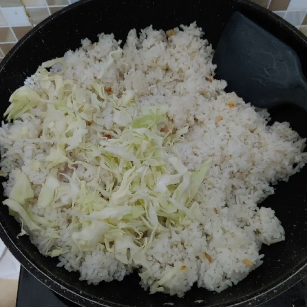 Masukan nasi, aduk rata lalu masukan sayur kubis. Aduk kembali hingga rata.