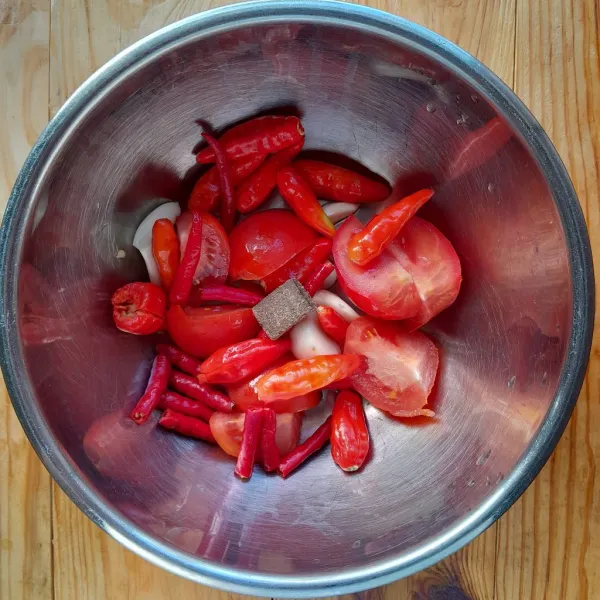 Potong-potong cabai rawit, cabai merah keriting dan tomat.