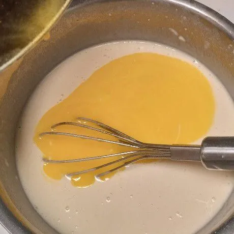Tambahkan margarine cair. Aduk. Menyusul soda kue. Aduk-aduk sampai benar-benar tercampur rata. Kemudian tutup dengan serbet bersih. Diamkan sekitar 1 jam.