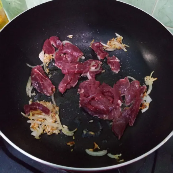 Tumis bawang putih dan bawang bombai sampai harum lalu masukkan daging sapi dan tuang air kaldu.