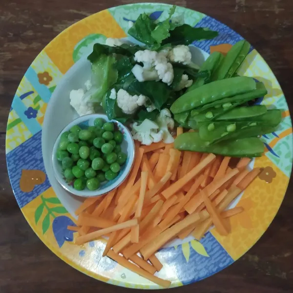 Siapkan wortel yang diiris korek, kembang kol, ercis, kapri frozen dan bawang putih cincang.