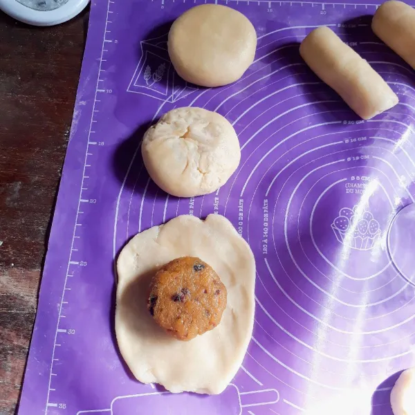 Bagi adonan menjadi 8, bulatkan. Pipihkan adonan dan isi dengan isian labu, rekatkan bagian pinggir kulit agar isi tidak keluar.