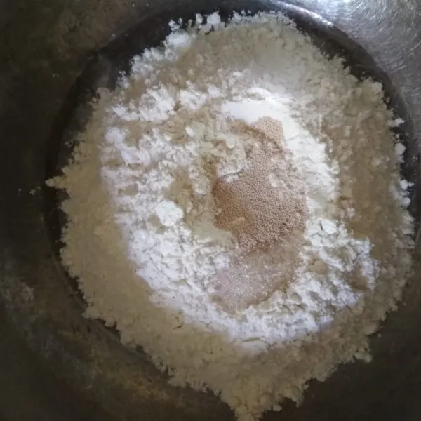 Dalam bowl campur tepung terigu, gula dan ragi, aduk rata.