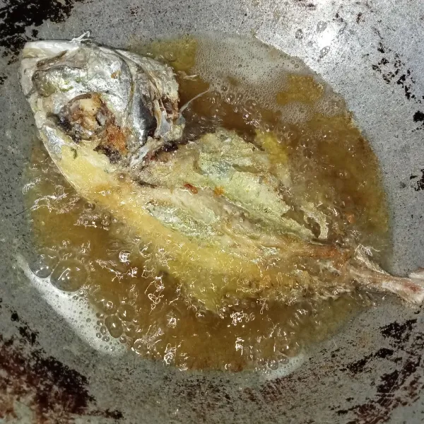 Cuci bersih ikan kemudian buang insangnya, lalu goreng ikan hingga setengah kering, tiriskan.