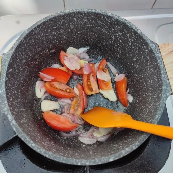 Tambahkan potongan tomat, tumis hingga layu.