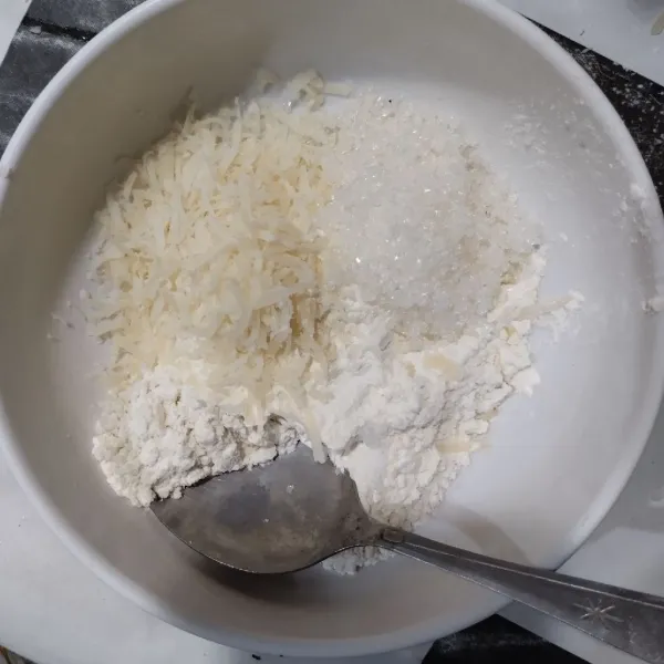 Campurkan tepung terigu, keju parut, garam dan gula pasir. Aduk rata.