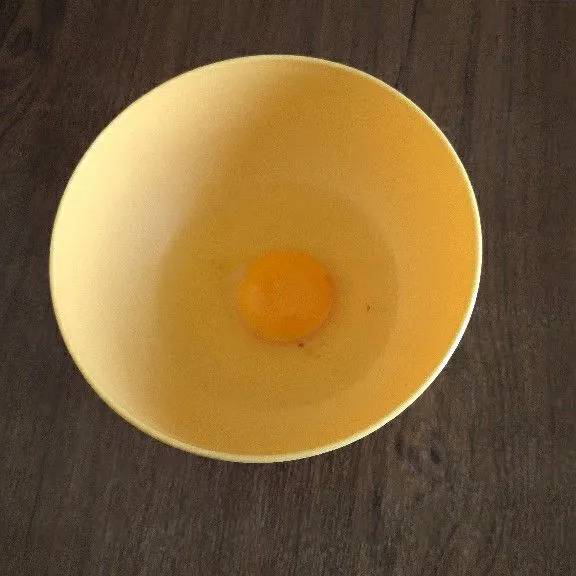 Pecahkan telur ayam lalu masukkan ke mangkok.
