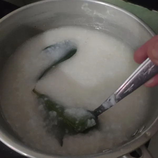 Blender nasi, masukkan ke dalam panci lalu tambahkan air secukupnya. Beri daun salam, garam, dan sedikit kaldu bubuk, aduk rata dan masak hingga kental seperti bubur, matikan.