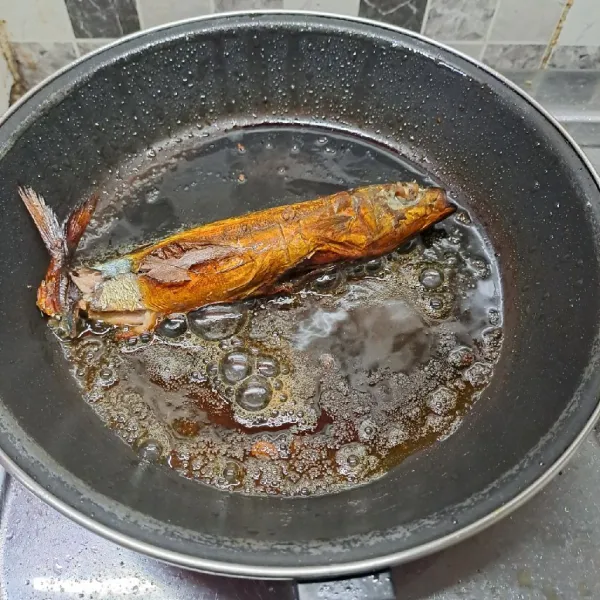 Panaskan pan dengan minyak secukupnya. Goreng ikan tongkol asap. Angkat dan sisihkan.