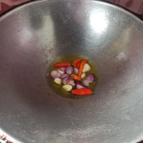 Panaskan minyak goreng secukupnya, masukkan bawang merah, bawang putih dan cabai rawit lalu goreng sampai layu.