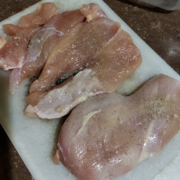 Belah tipis daging ayam. Tusuk-tusuk dengan garpu kemudian baluri dengan garam dan lada. Diamkan 5 menit.