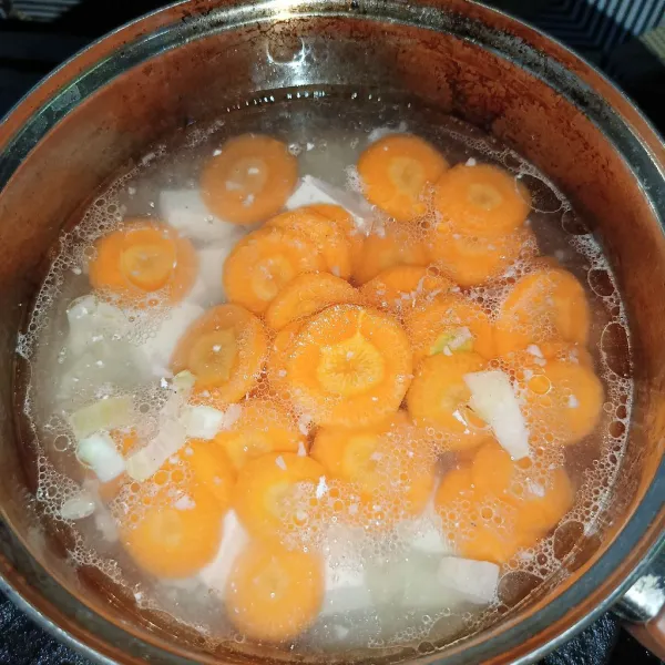 Setelah mendidih masukkan tahu dan wortel, masak sampai wortel empuk.