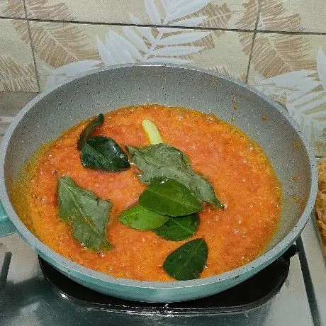 Tumis bumbu halus sampai harum, lalu masukkan daun salam, daun jeruk, dan serai. Tumis sampai matang.