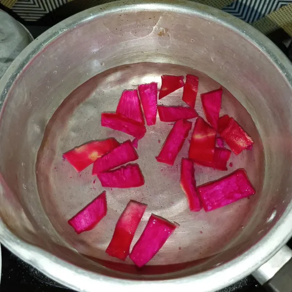 Rebus kulit buah naga dan air sampai mendidih dan berubah warna.
