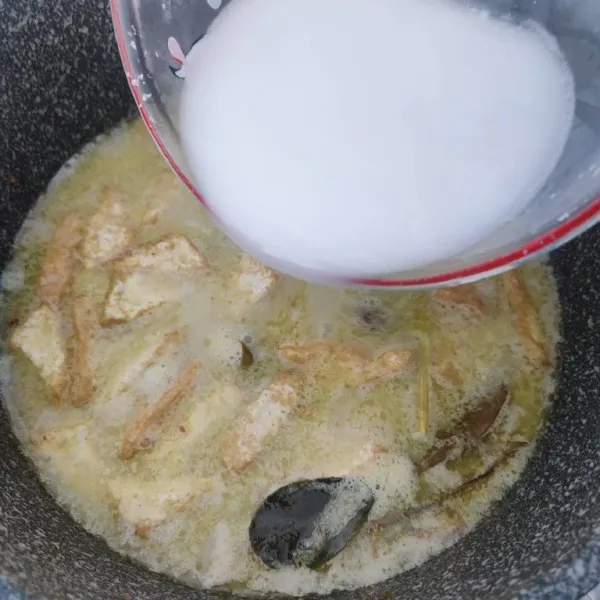 Masukkan tahu goreng dan santan kental, rebus kembali sambil diaduk hingga mendidih.