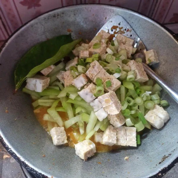 Setelah bumbu matang tambahkan air, kemudian masukkan daun bawang, labu siam, tempe dan daun salam masak hingga labu siam empuk.